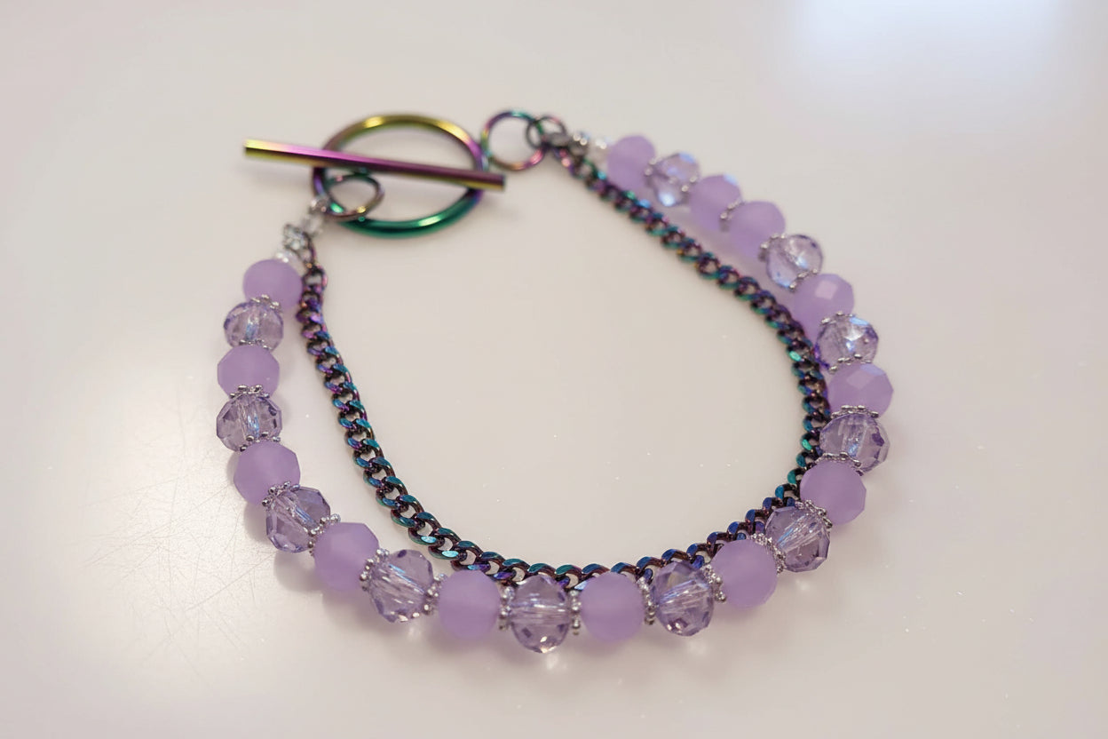 Bracelet with purple beads and a colorful clasp on a white background