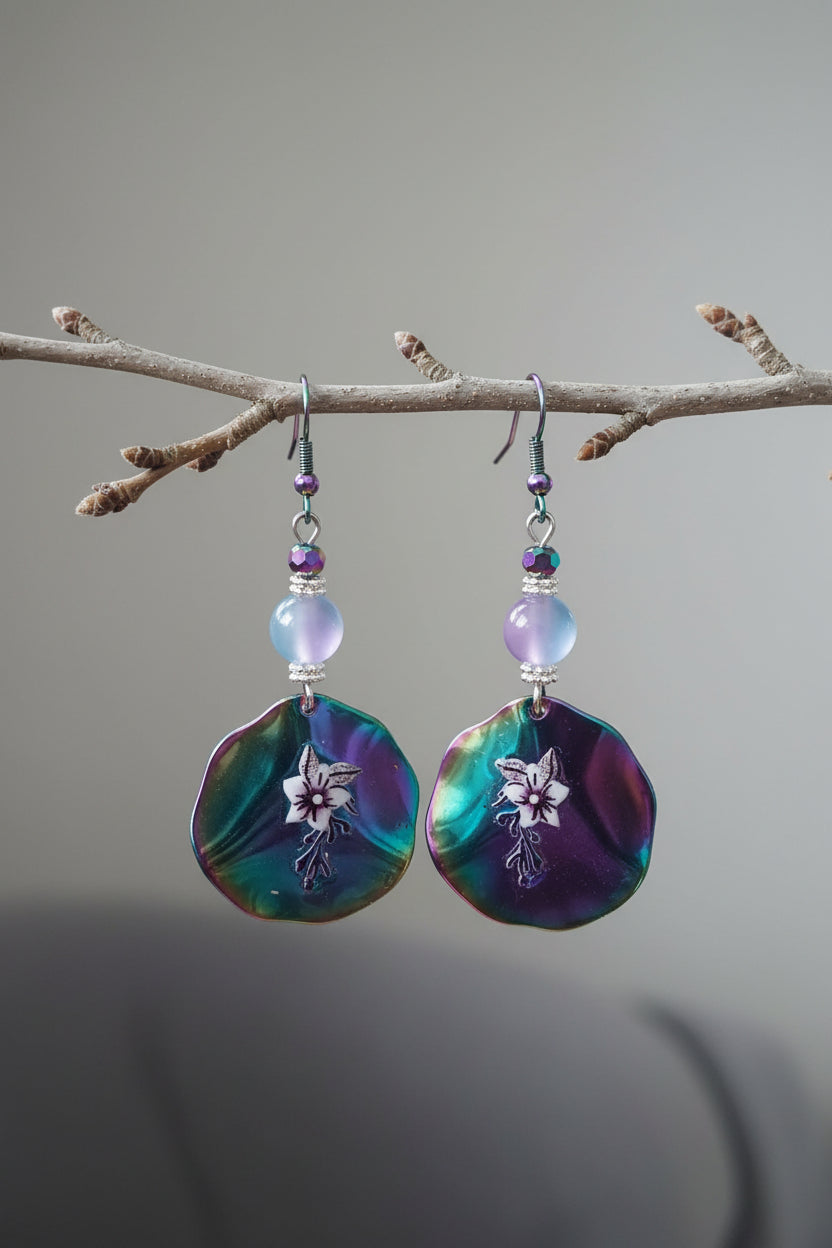 Multicolored beaded earrings held in a hand with a blurred background