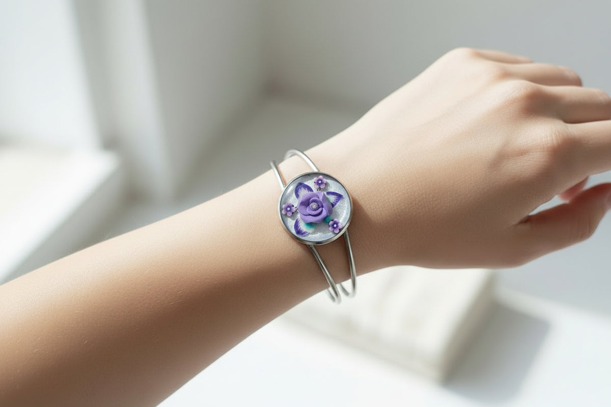 Silver bracelet with a purple floral design on a beige background