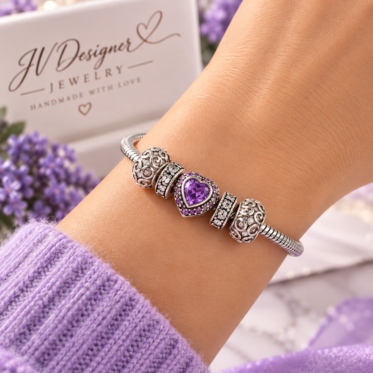 Purple heart charm bracelet with silver-plated snake chain worn on wrist, close-up view