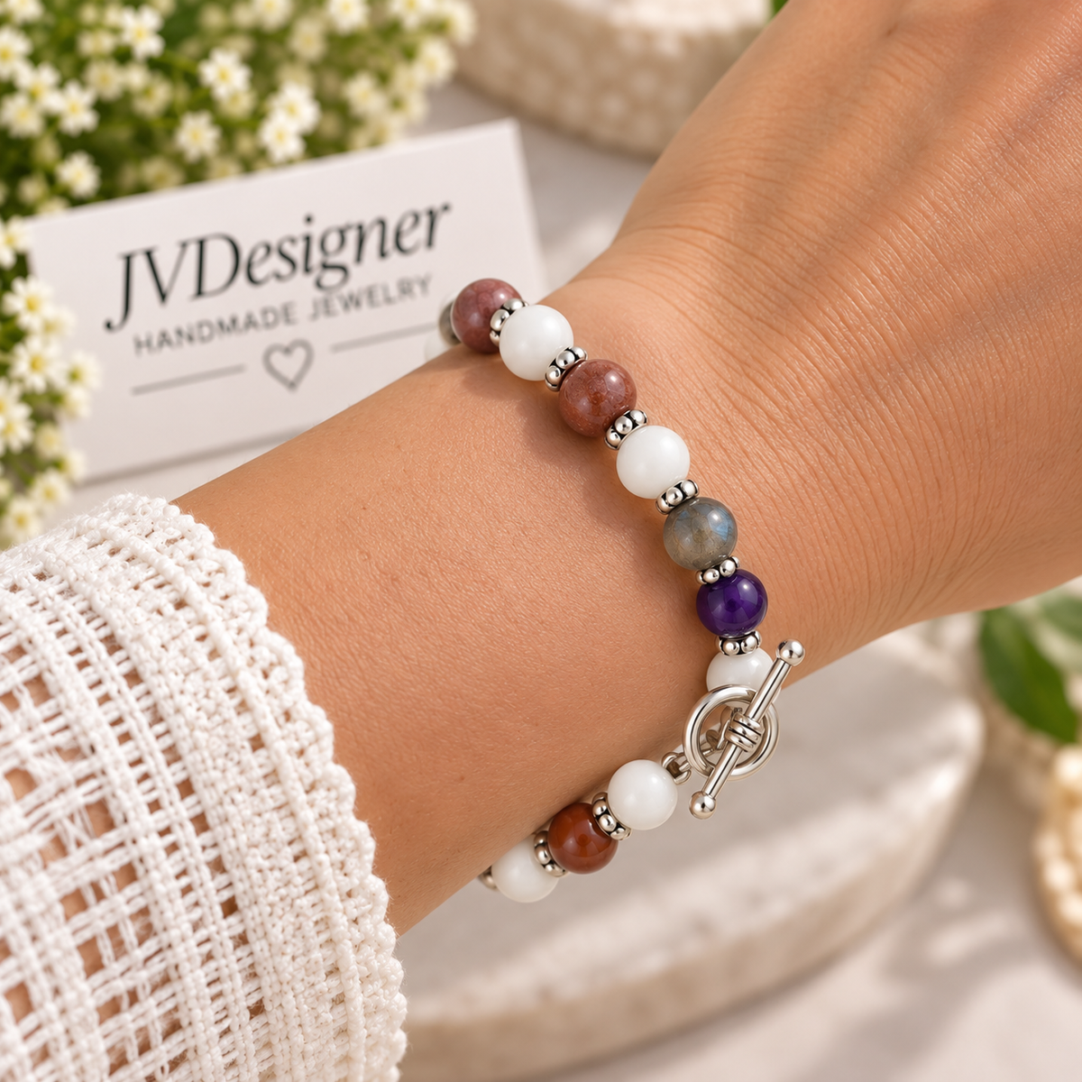 Purple white stone stretch bracelet with silver toggle clasp worn on wrist, close-up view