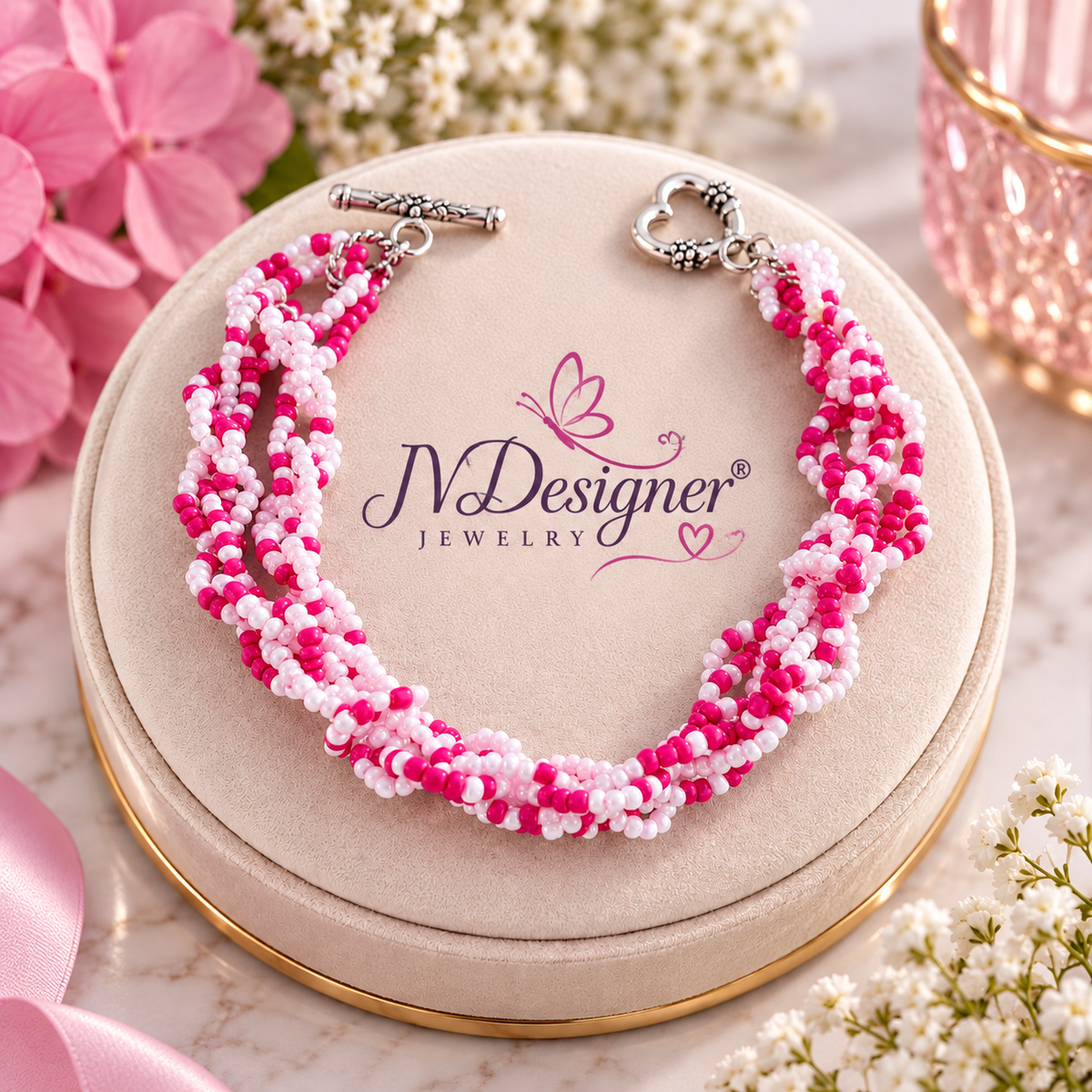 Pink seed bead bracelet with silver toggle clasp displayed on jewelry box with flowers