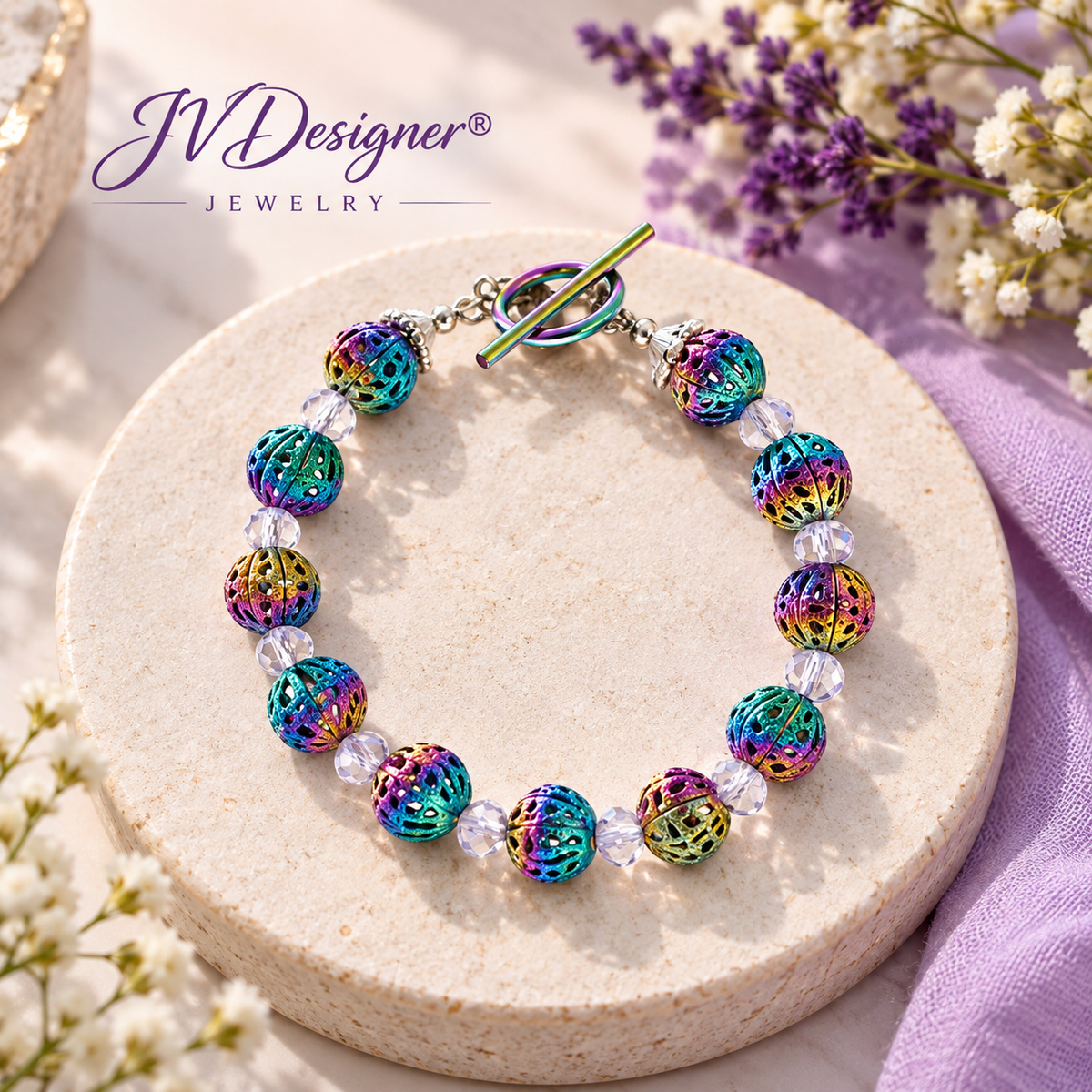 “Handmade colorful rainbow bead bracelet with iridescent filigree beads and clear crystal spacers on a round display, JVDesigner Jewelry.”