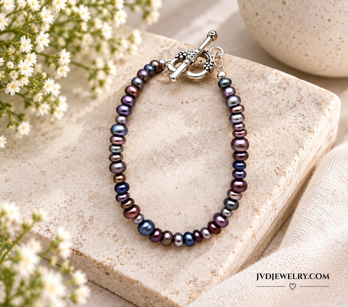 Colorful pearl bracelet in purple, blue and bronze with silver heart toggle clasp