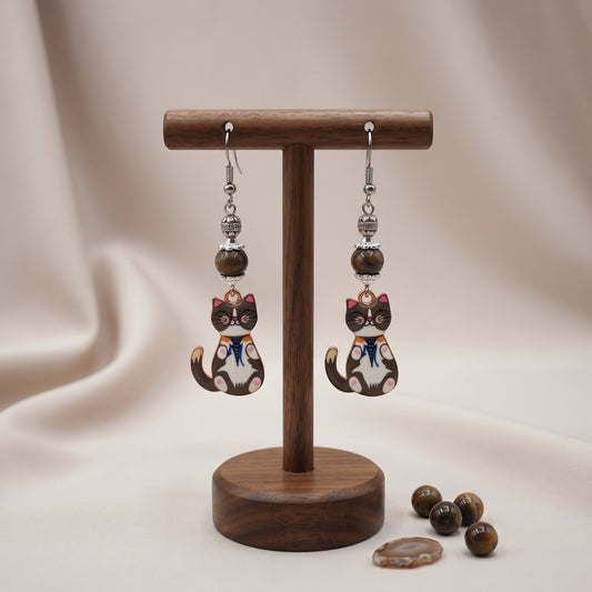 Handmade enamel cat dangle earrings with colorful gemstone beads and silver hooks on stand