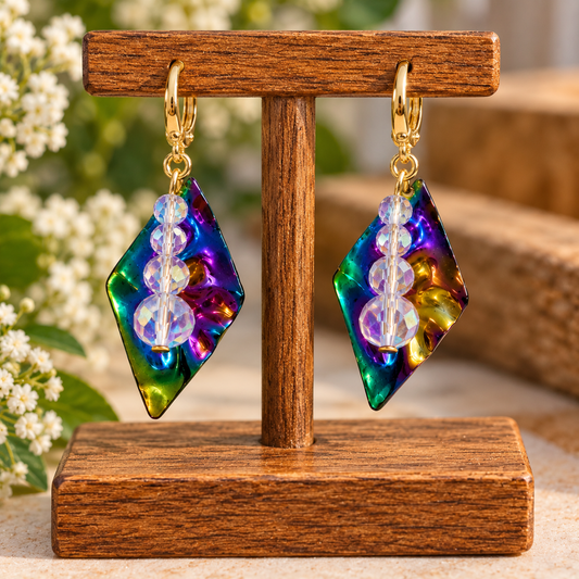 Rainbow crystal dangle earrings with iridescent pendants on a display stand