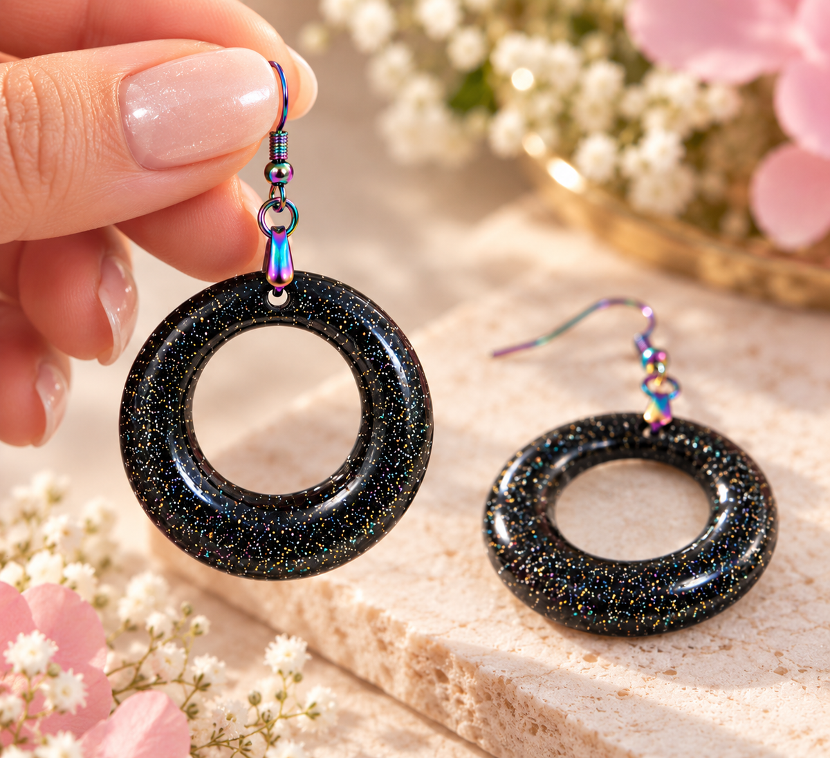 Close-up of black resin hoop earring with glitter