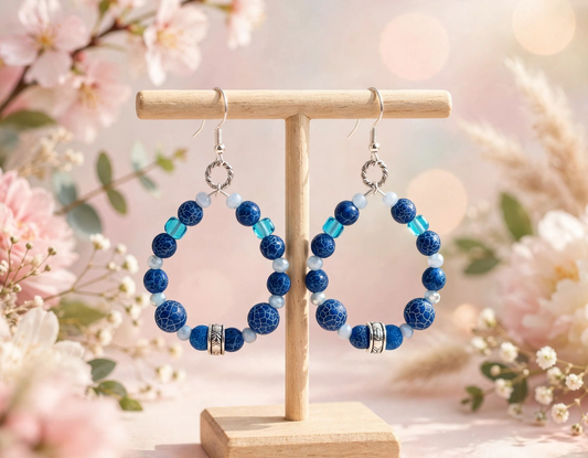 Blue crackle bead hoop earrings with turquoise cube beads on wood display stand