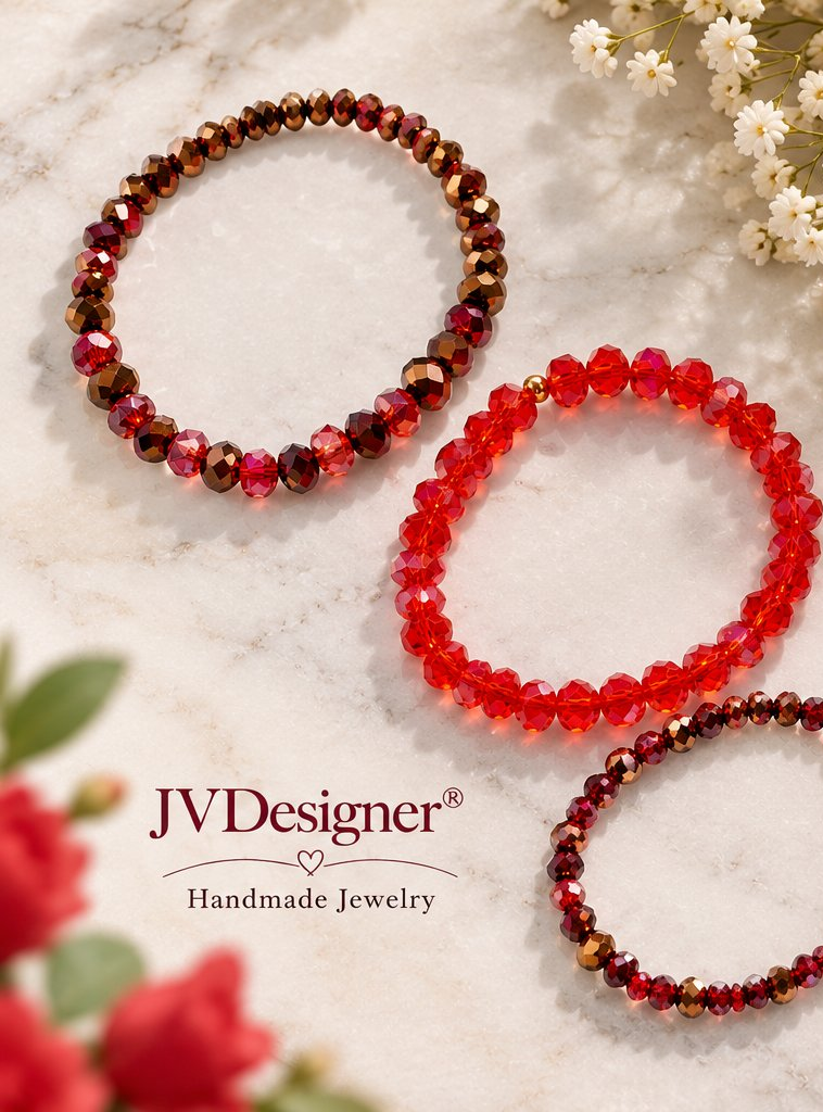 Three beaded stretch bracelets by JVDesigner arranged on a light marble surface with small white flowers and red roses. The bracelets feature faceted beads in red, deep burgundy, and brown tones, with one bracelet showing small gold-toned spacer beads.